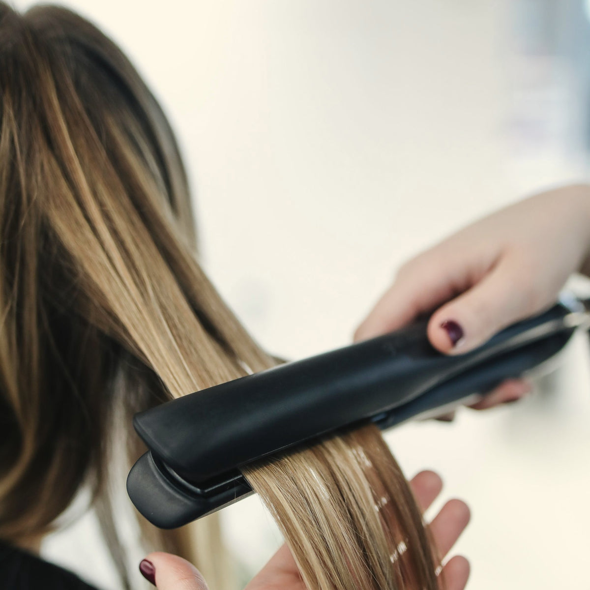 Professional smoothing treatment in progress: flat iron through long hair – COIFFLISS smoothing kits